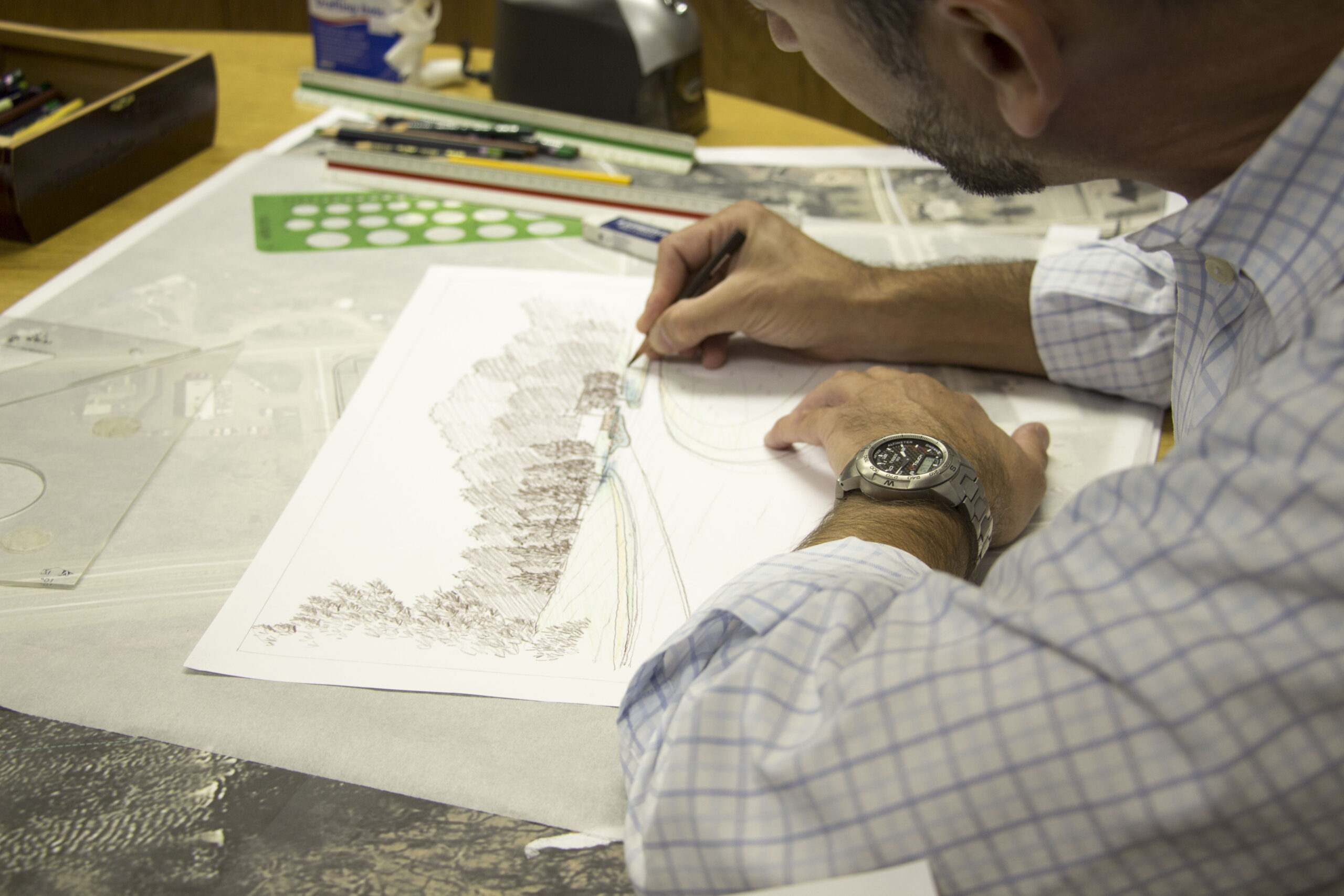 Man sketches landscape on paper