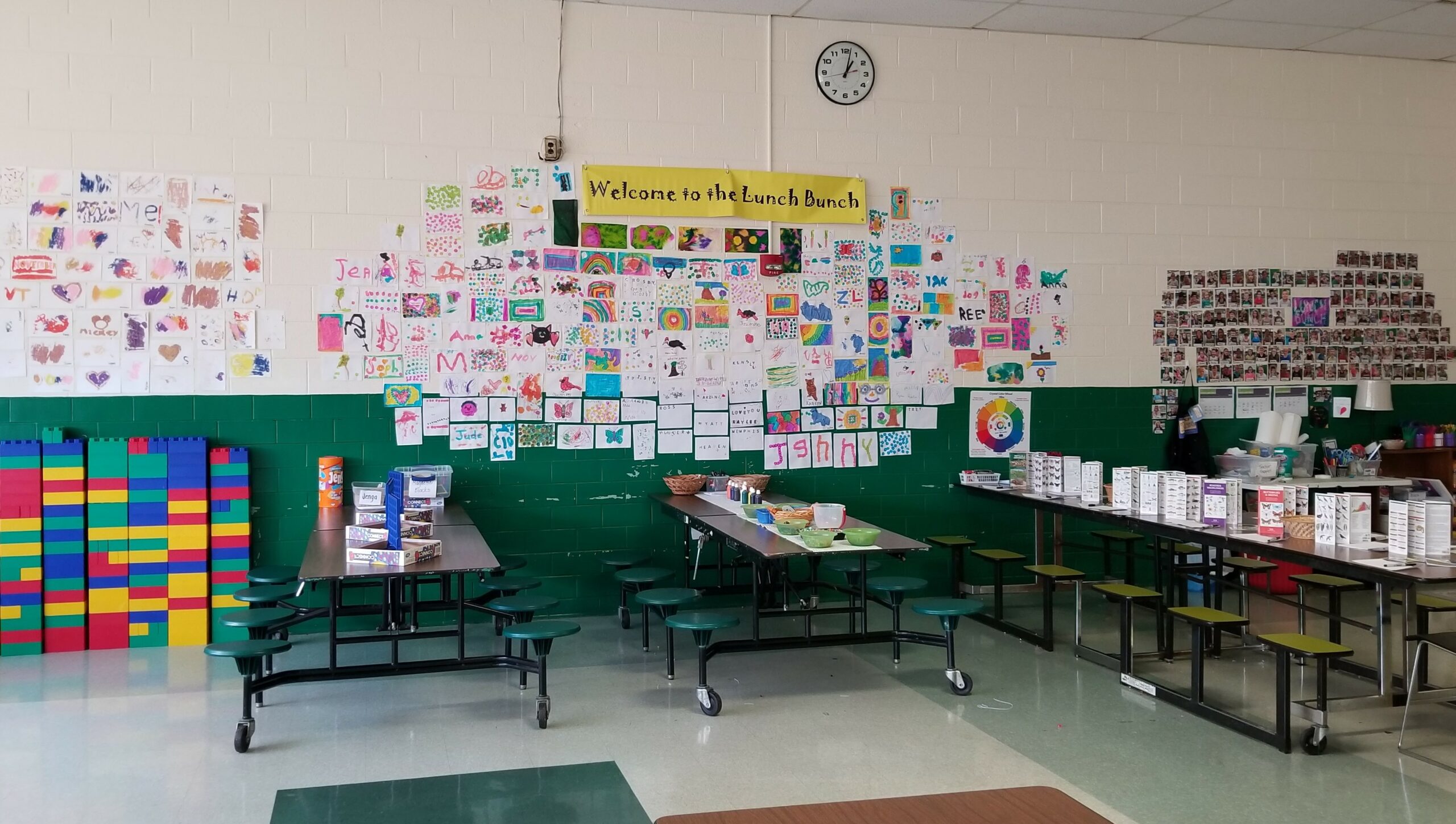 Cafeteria tables under display of student artwork
